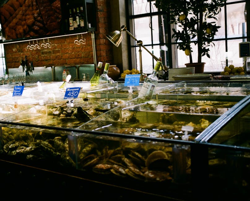 Wall of glass tanks filled with live fish and seafood in a Guangzhou restaurant